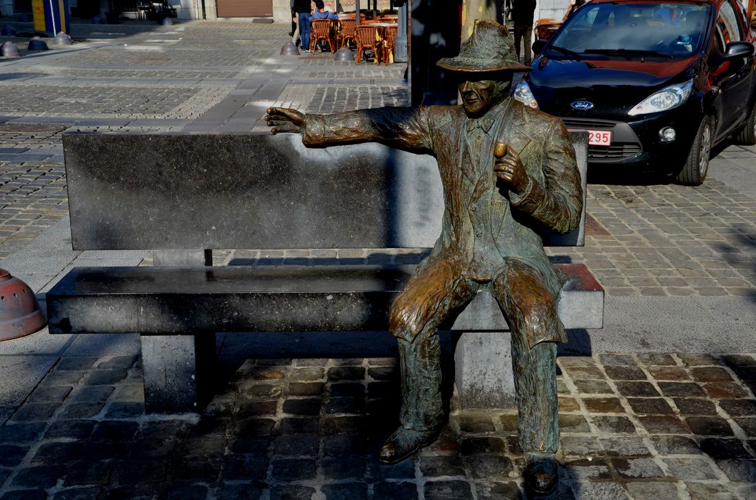 Een monument in de vorm van een bank waarop de beroemde schrijver van misdaadromans Georges Simenon zit. Luik, België. 